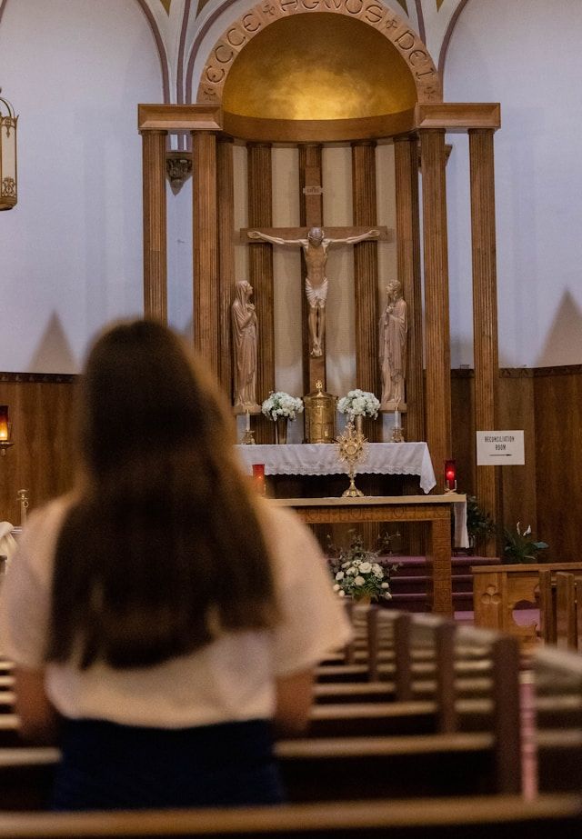 mujer orando frente a la hostia consagrada